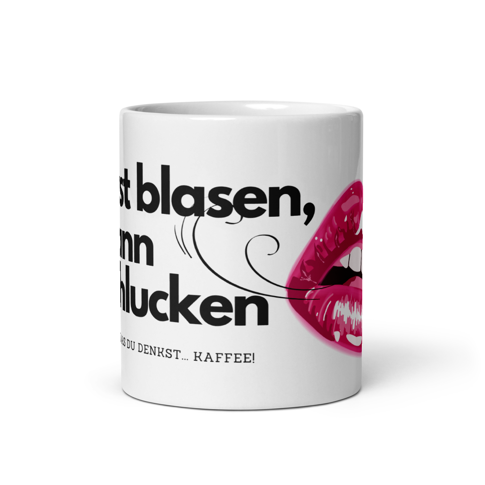 Schräge Vorderansicht einer weißen Kaffeetasse mit schwarzem Spruch, Windhauch-Grafik und einem pinken Lippen-Motiv auf schwarzem Hintergrund.