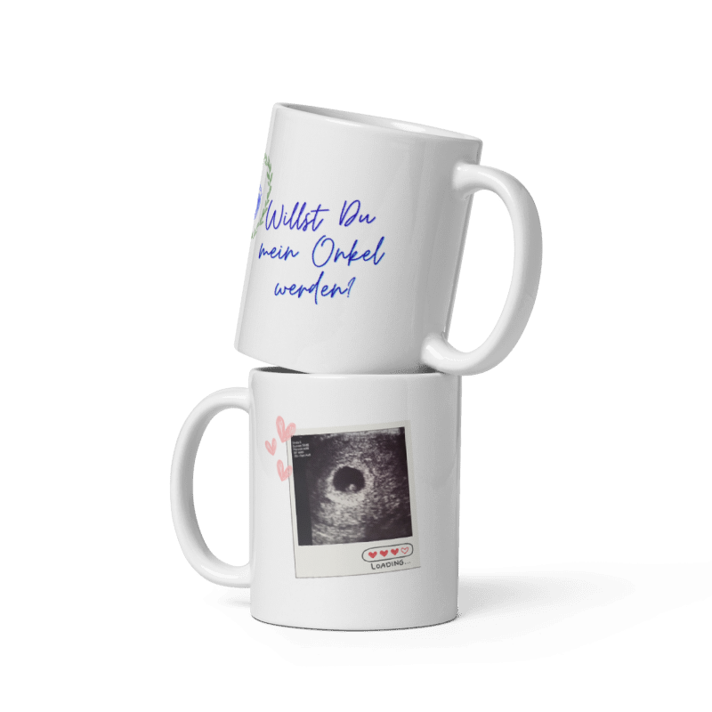 Zwei weiße Kaffeetassen übereinander gestapelt: Die obere zeigt den blauen Schriftzug „Willst Du mein Onkel werden?“, die untere ein Ultraschallbild im Polaroid-Stil mit der Aufschrift „Loading...“.