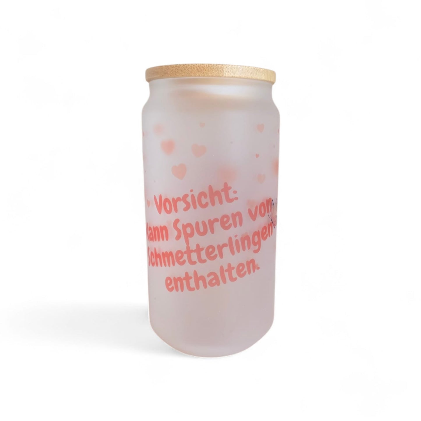 Seitliche Ansicht des mattierten Glases „Schmetterlingsmomente“, das den Schriftzug „Vorsicht: kann Spuren von Schmetterlingen enthalten“ und ein filigranes Schmetterlingsmotiv zeigt.
