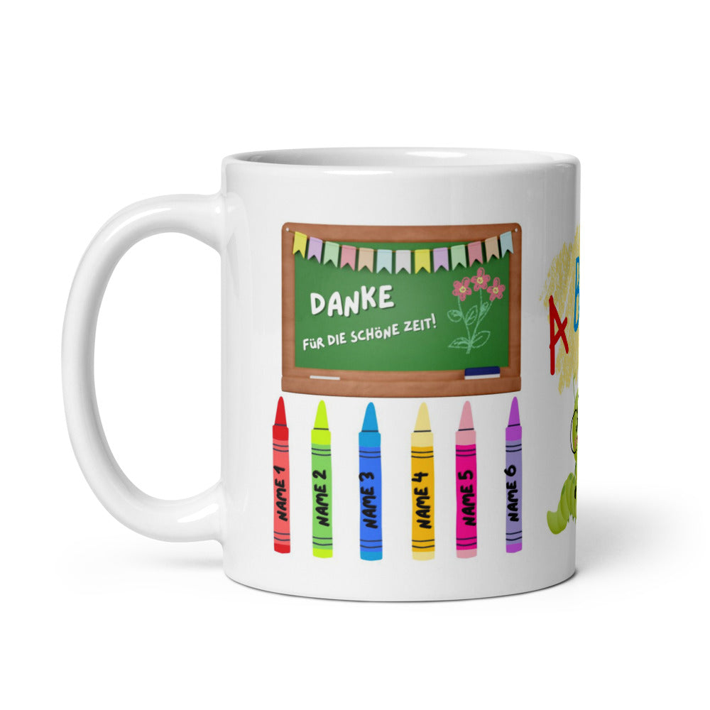 Weiße Keramiktasse als Abschiedsgeschenk für Lehrer, bedruckt mit einem Schultafel-Motiv „DANKE FÜR DIE SCHÖNE ZEIT!“, bunten Wachsmalstiften mit Platzhaltern für Schülernamen und einer ABC-Raupen-Illustration.