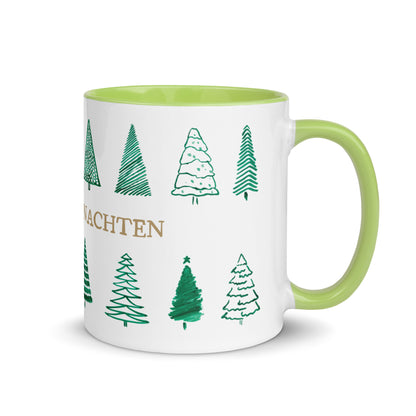 Weiße Weihnachtstasse mit goldenem Schriftzug und verschiedenen handgezeichneten Tannenbäumen, grüner Henkel und grüne Innenseite