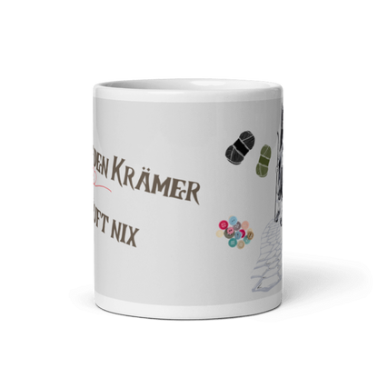 Tasse mit Spruch “Ohne den Krämer läuft nix”, Motiv: alter Krämer mit Wanderstock, Nadel und Faden, Wollknäuel, Schere und Knöpfe- frontansicht
