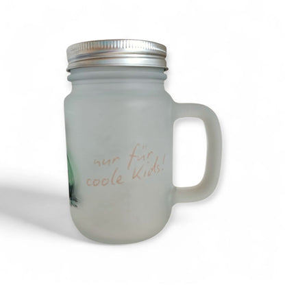 Ein mattiertes Henkelglas mit Schraubdeckel, verziert mit einer Illustration einer gruener Zaubertrank-Flasche und dem Schriftzug „nur für coole Kids!“ in einer verspielten Schriftart.
